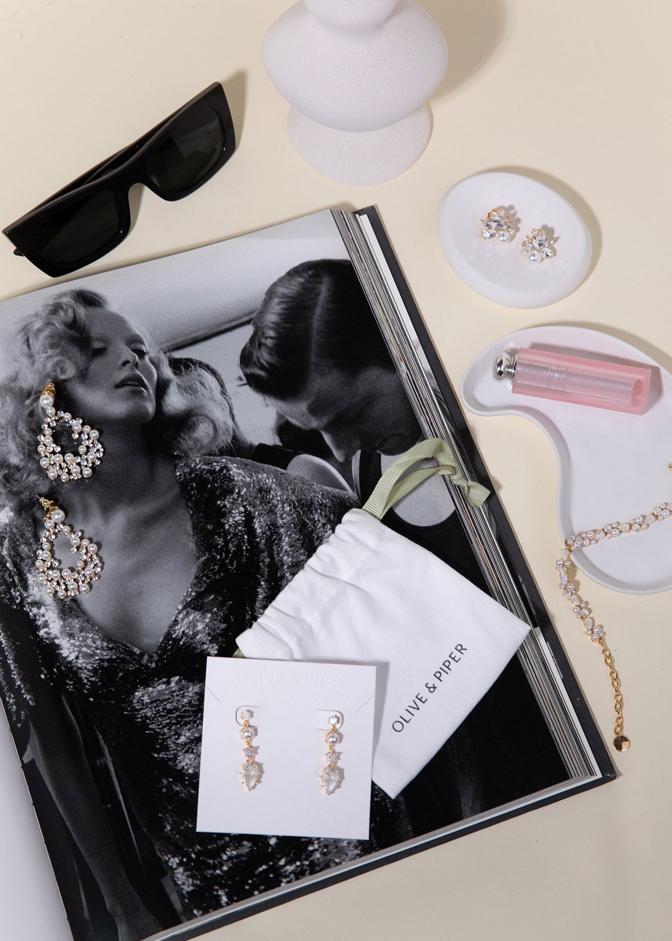 Jewelry set with earrings and a book on a light background